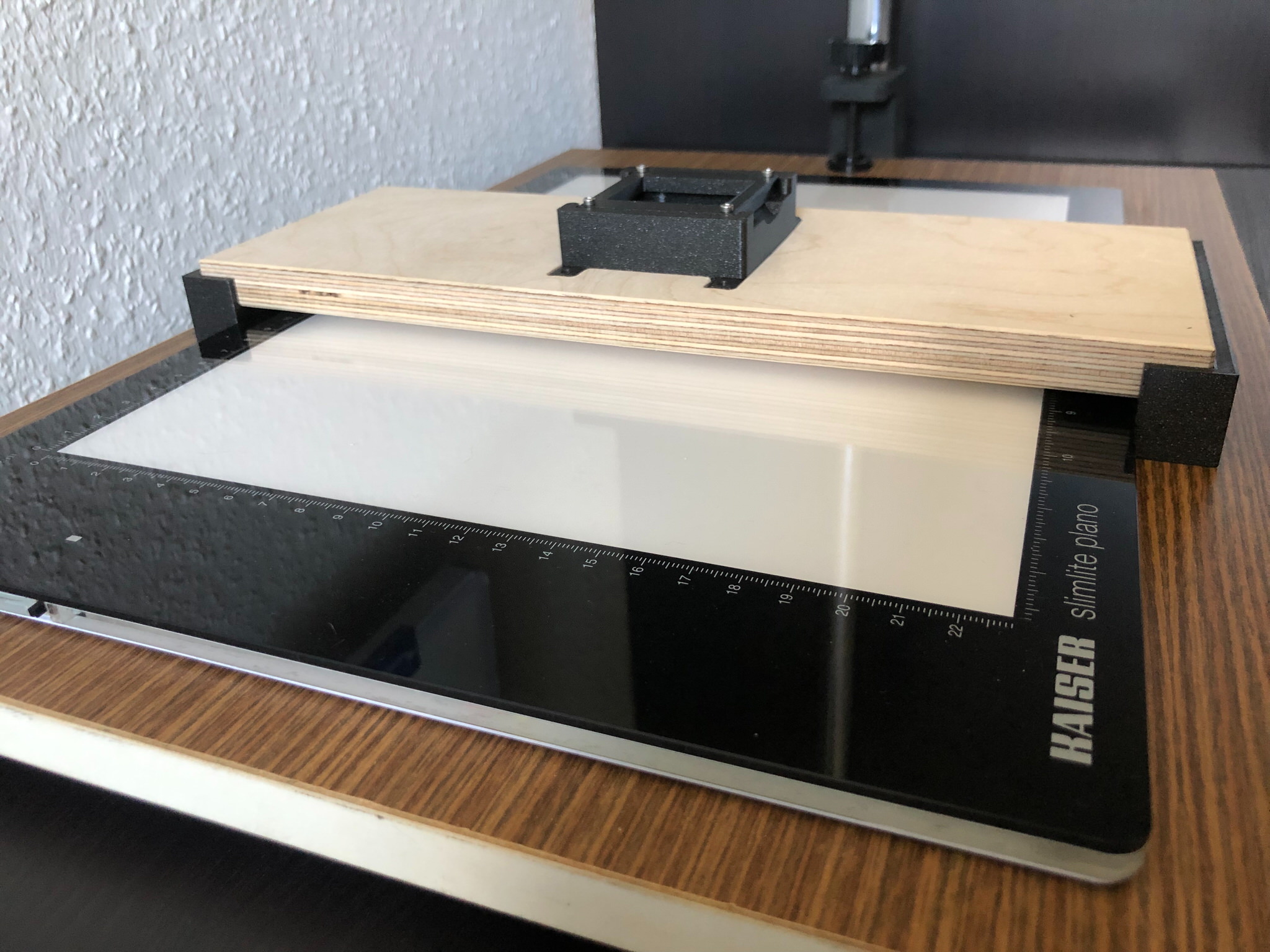 Das finale Modell hat nun eine verschiebbare Brücke, so passt die Leuchtplatte besser auf den Reprotisch, die Füße für das Holzbrett stammen nun ebenfalls aus dem 3D-Druck damit das Filmmaterial in der Waage liegt. Die Konstruktion bietet dennoch ausreichend Stabilität um ein Verrutschen des Bildausschnitts beim Wechsel des Dias oder Weitertransport des Filmstreifens zu unterbinden.