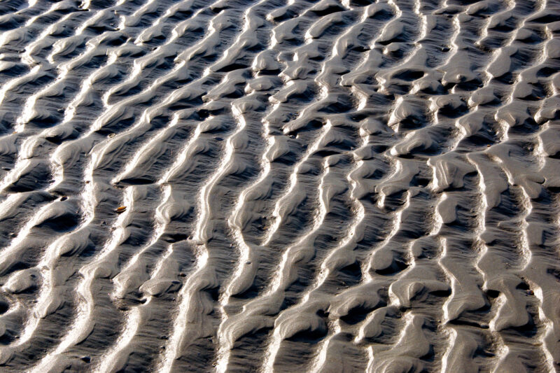 Fotografische Wahrnehmung - minimalistische Muster am Strand durch Licht und Schatten verstärkt